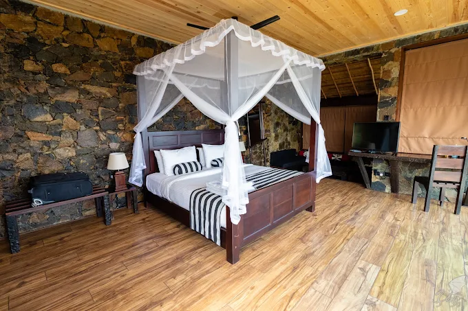 98 Acres Resort 객실 내부와 캐노피 침대